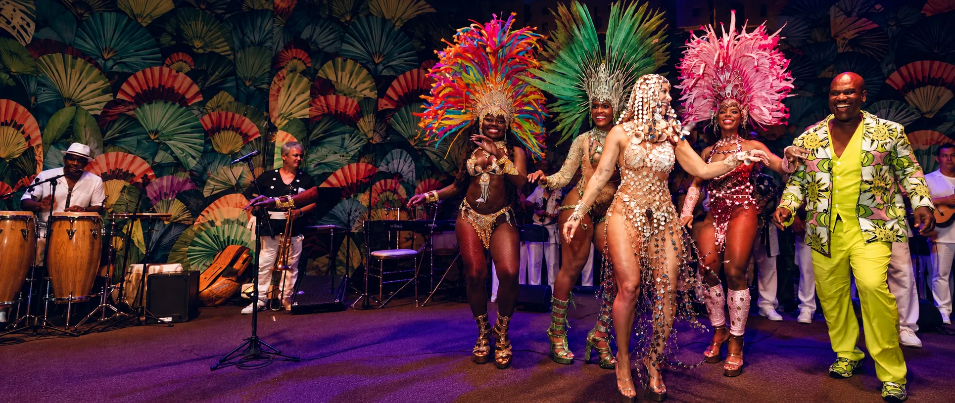Bailarines de samba con sus trajes y la reina del Baile de Copacabana, luciendo una banda adornada con joyas, actúan en el escenario junto a la banda en vivo en el Copacabana Palace.